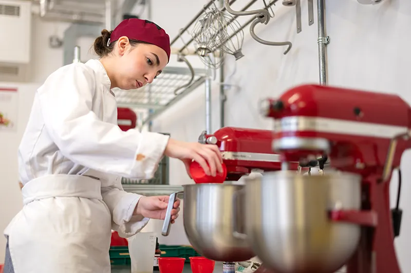 student using a mixer in the kitchen