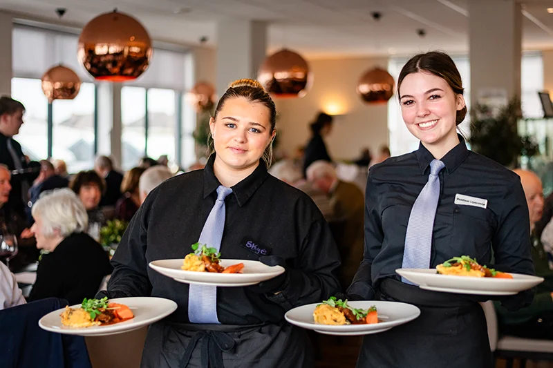 Two female students serving food