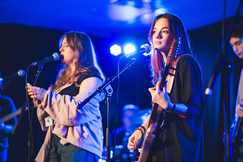 Girl singing and a girl playing a guitar
