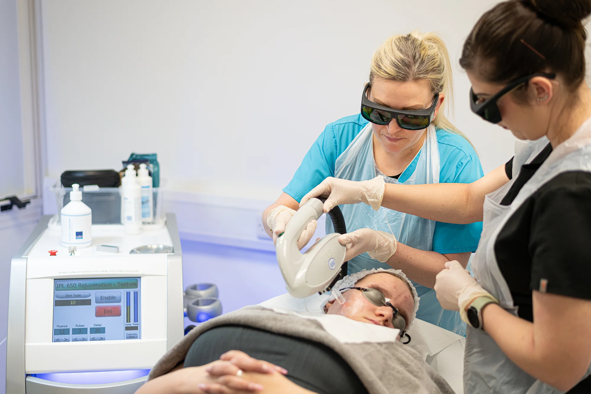 Mature student and lecturer using laser treatment on a lady