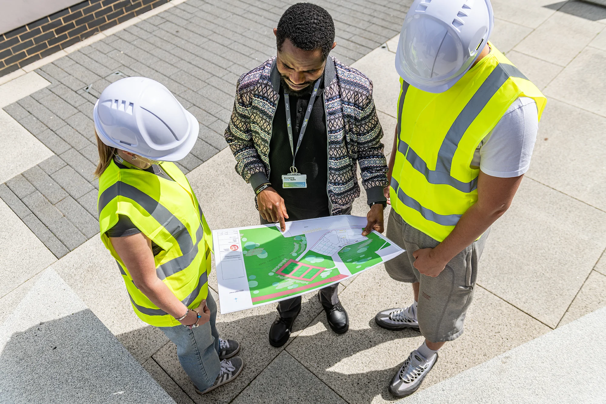Two students and lecturer looking at site plans