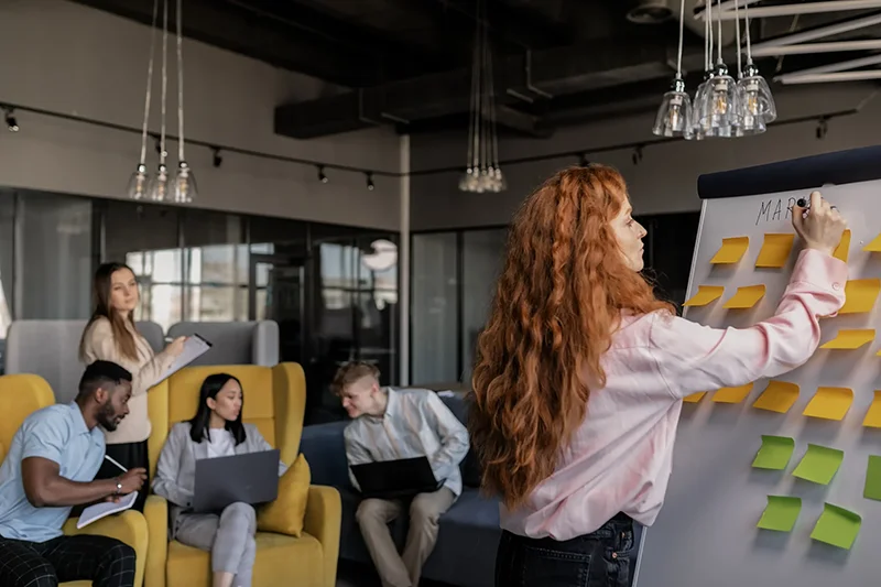 Students watching a lecturerput their ideas on a whiteboard